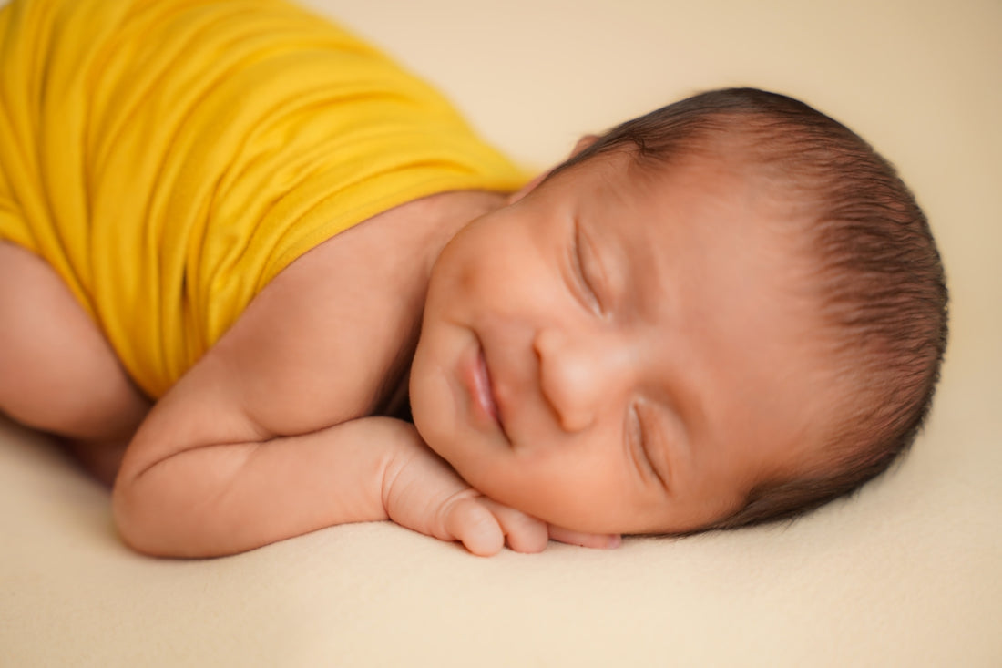 Newborn baby sleeping peacefully in yellow outfit