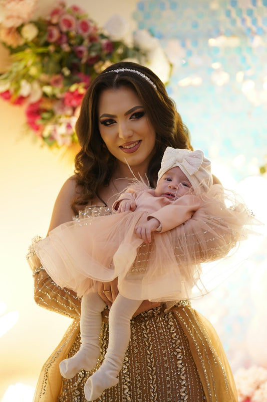 Mother holding her baby in a festive setting.