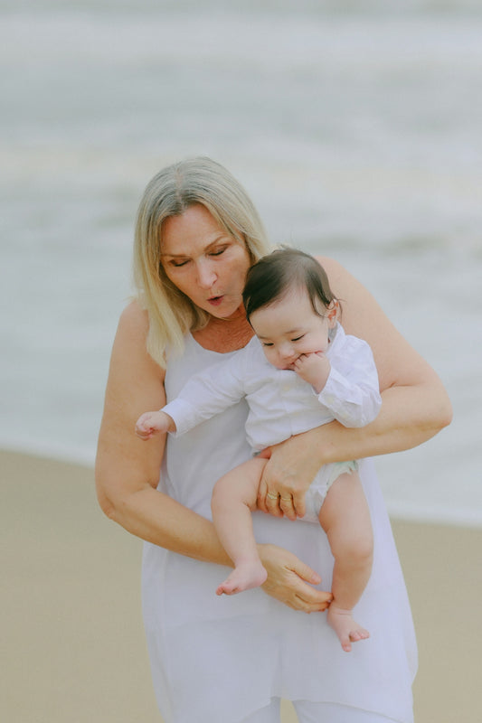 Woman holding a baby on the beach