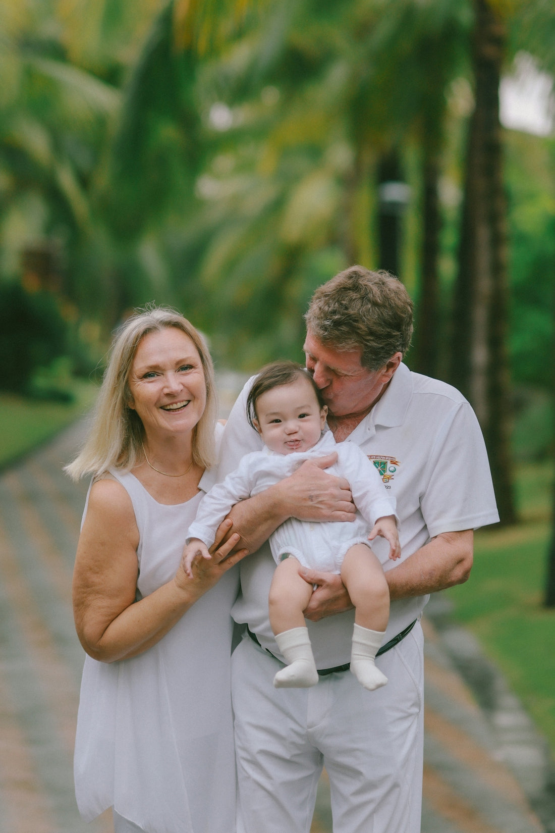 Grandparents holding their baby outdoors