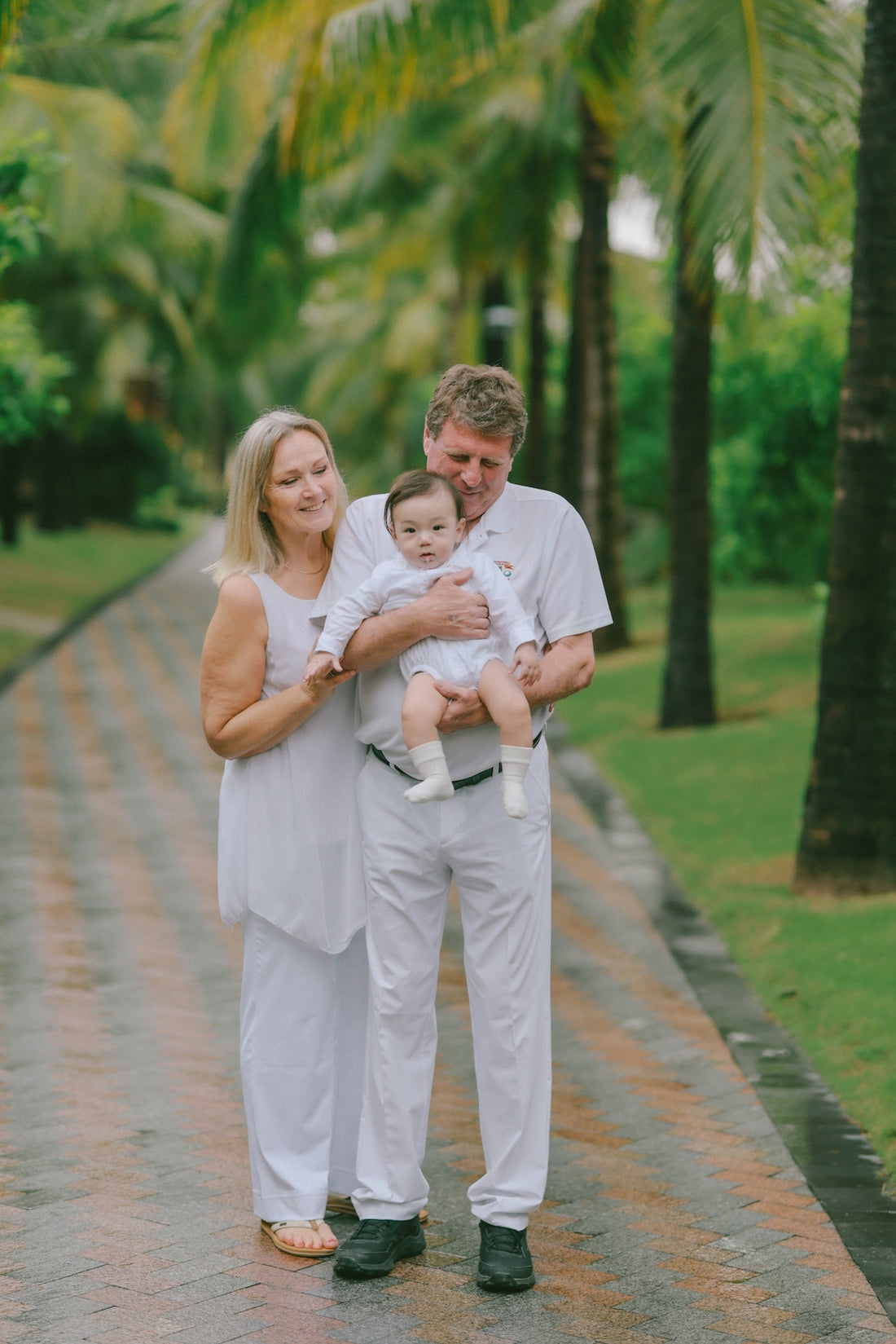 Couple holding a baby in a tropical setting