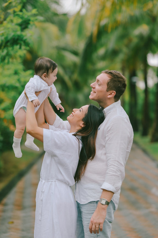 Parents holding their baby in a park