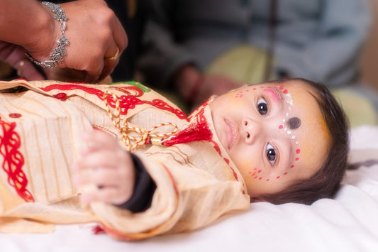 A baby in traditional indian clothing with face paint.