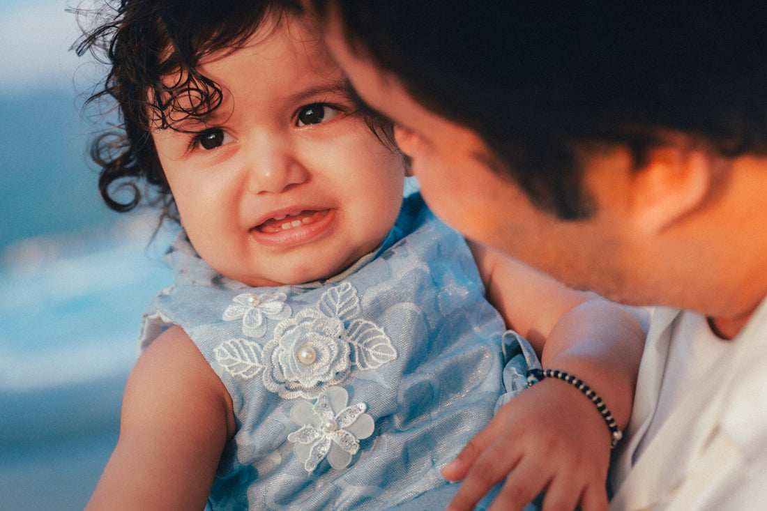 Father holding his baby daughter close to his face
