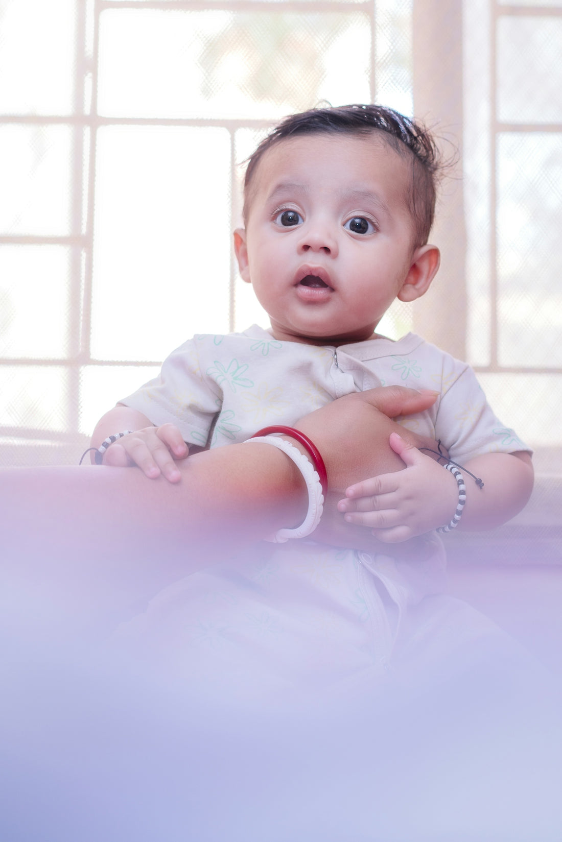 A baby with wide eyes and open mouth looks surprised