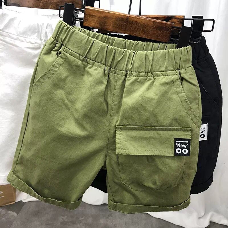 Green elastic waist casual shorts with front pockets and patch detail on wooden hanger