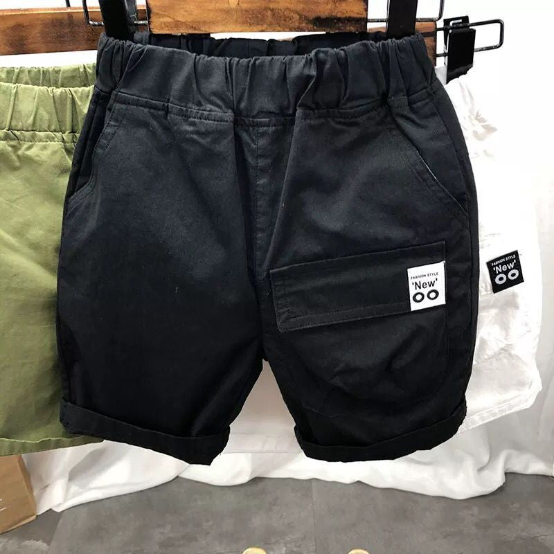 Black casual shorts with elastic waistband and side pockets hanging on wooden hanger