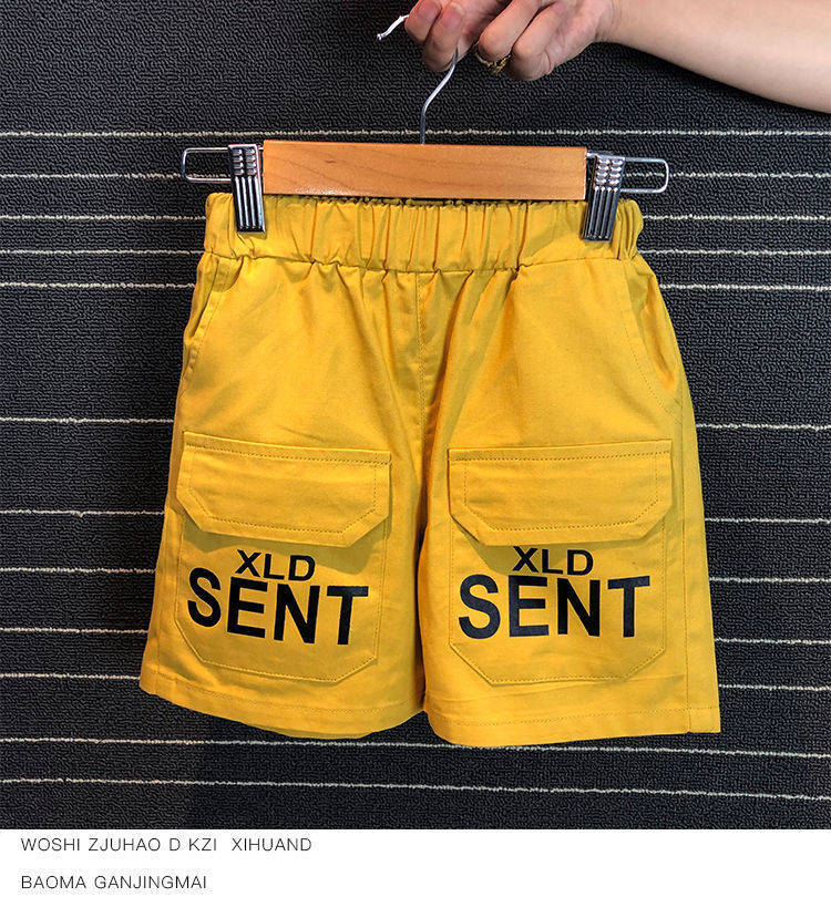 Bright yellow kids shorts with elastic waistband and large front pockets labeled XLD SENT
