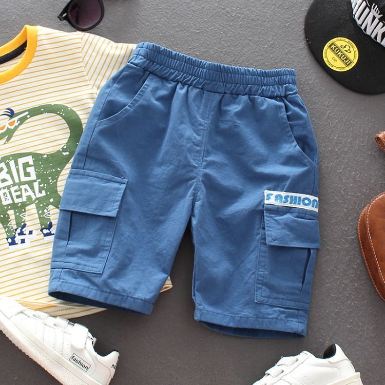 Blue boys cargo shorts with elastic waistband, paired with dinosaur print t-shirt and white sneakers