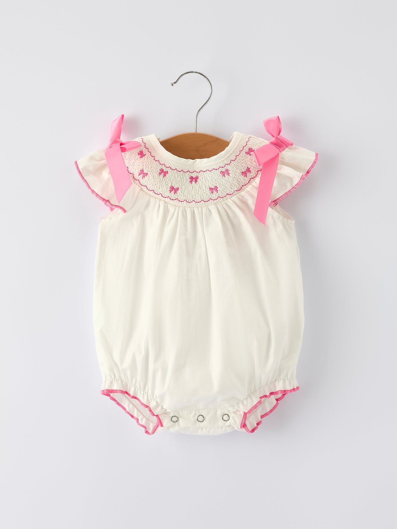 Baby romper with pink bows on a white background