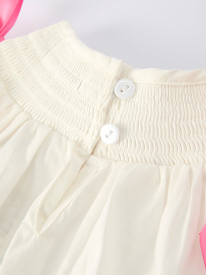 Close-up of a white dress with buttons on a light gray background