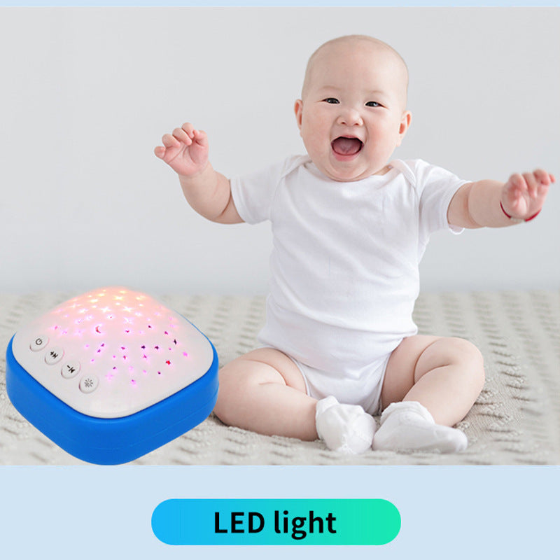 Happy baby sitting next to a blue LED night light projector with star patterns
