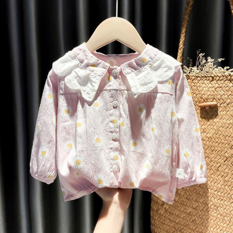 Light pink baby shirt with white daisy prints and large white collar on wooden hanger