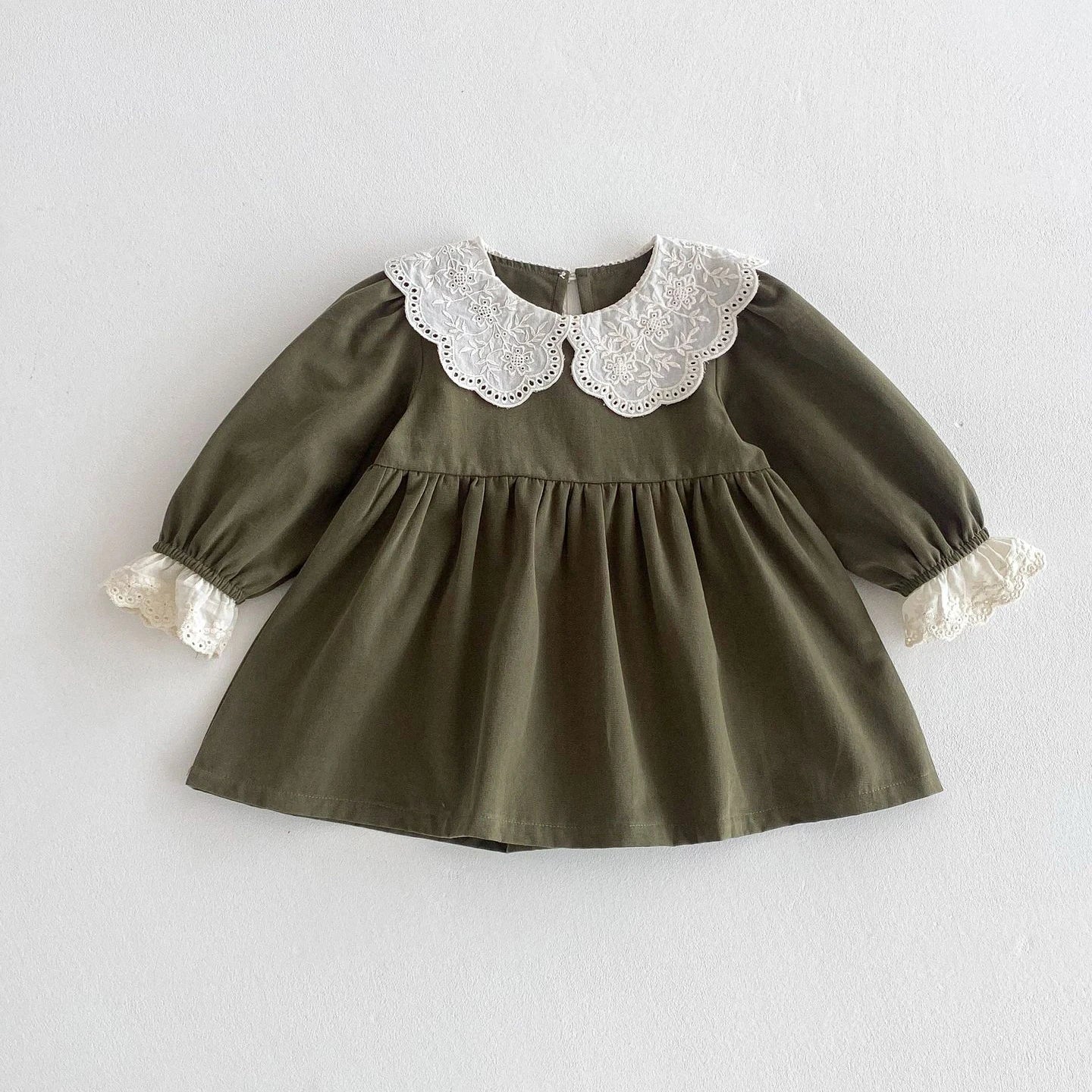 Green dress with lace collar and cuffs on a light gray background