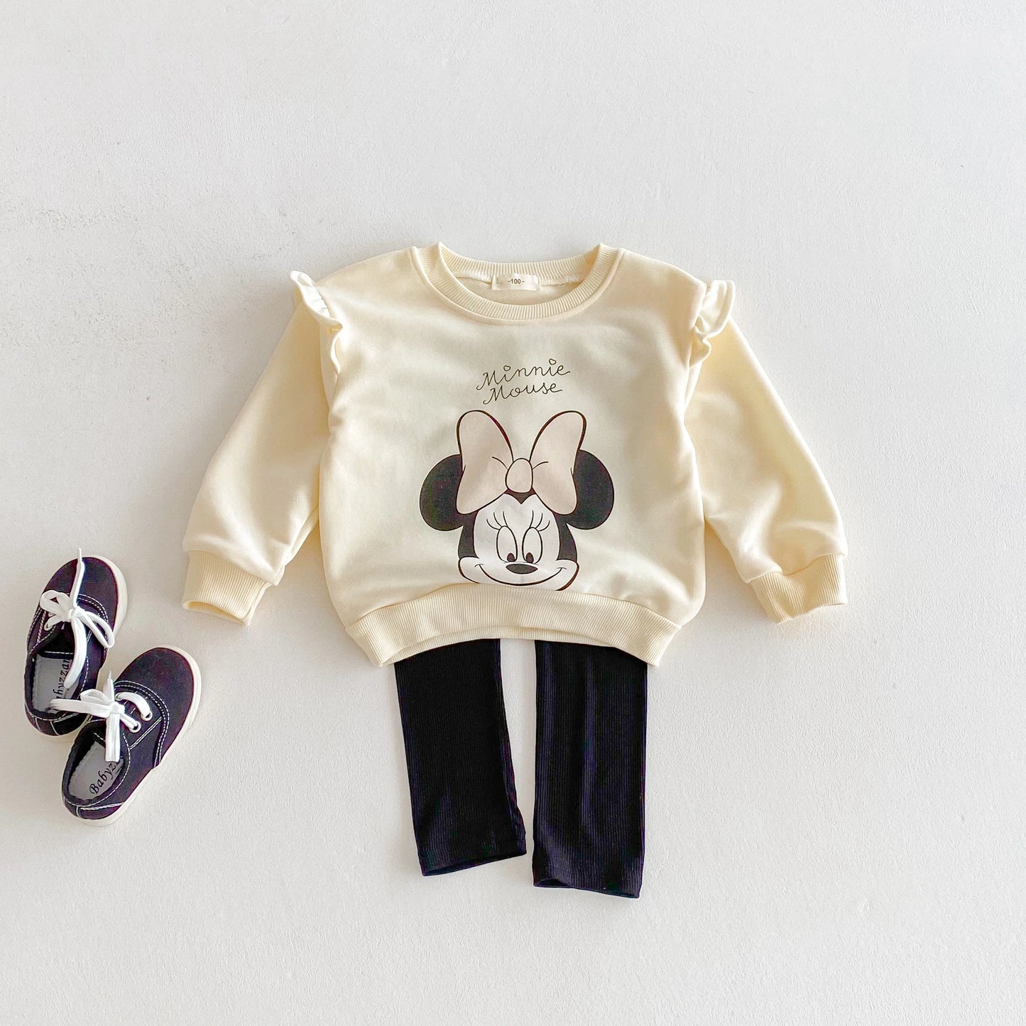 Children's outfit with Minnie Mouse sweatshirt and pants on a light background