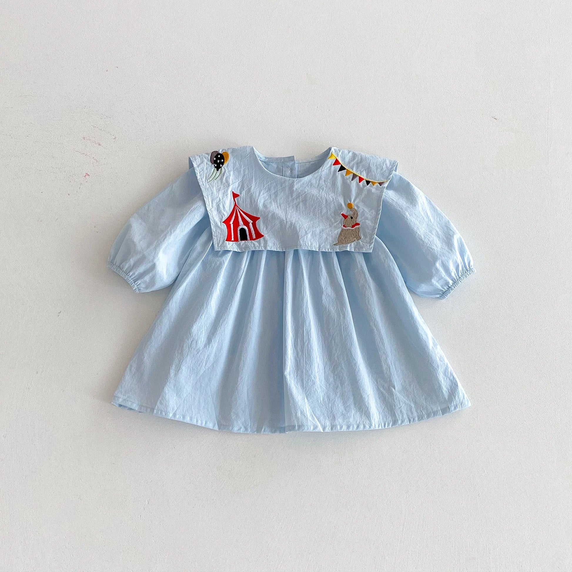 Light blue dress with circus-themed appliqué on a white background