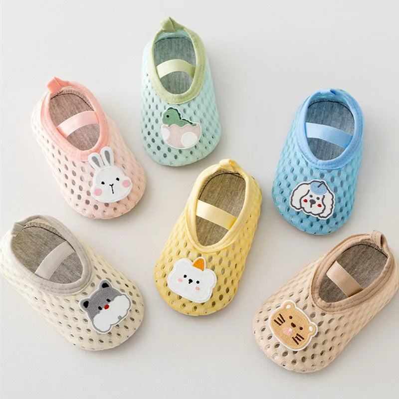 Set of colorful baby shoes with animal face designs on a light background