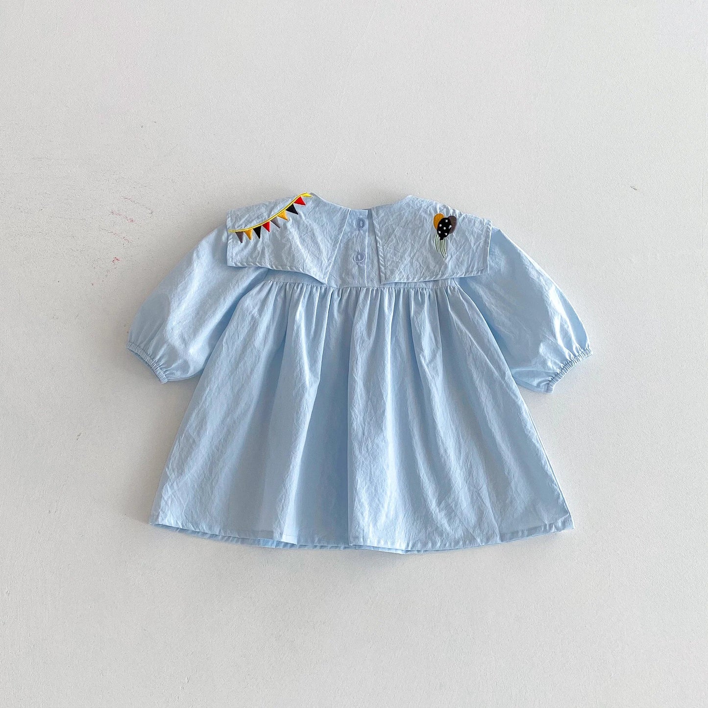Light blue dress with embroidered details on a white background