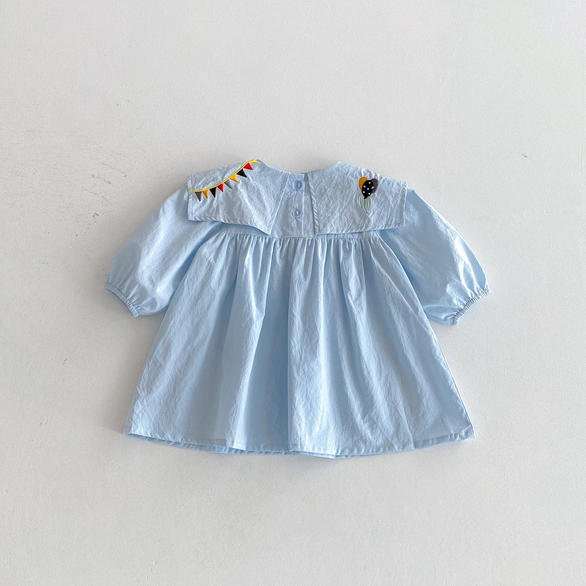 Light blue dress with embroidered details on a white background