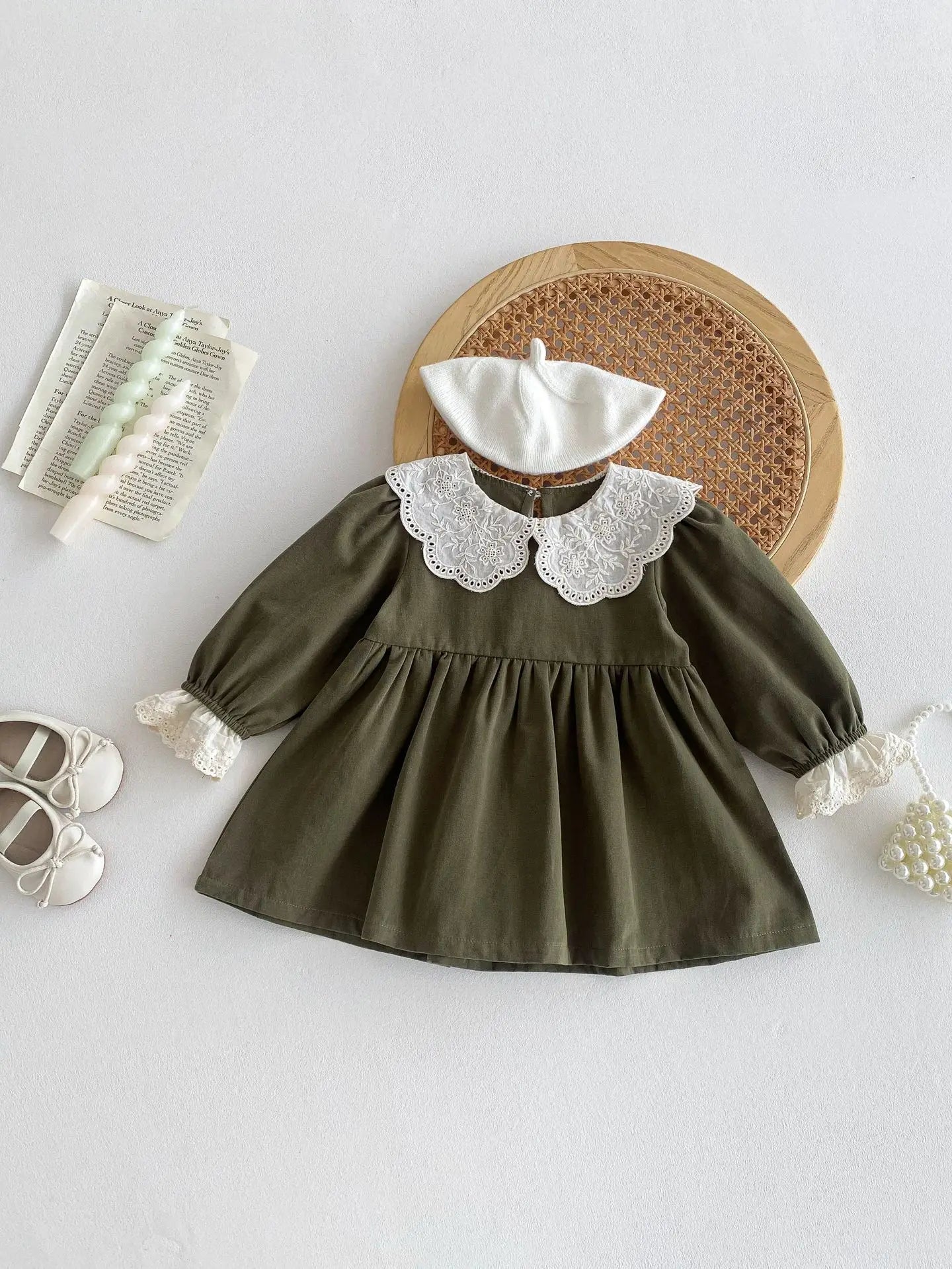 Green dress with white lace collar on a light gray background