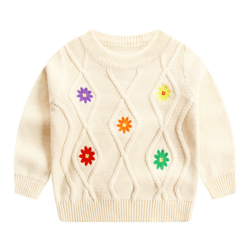 Cream knit sweater with colorful embroidered flower patterns in diamond shapes and ribbed cuffs