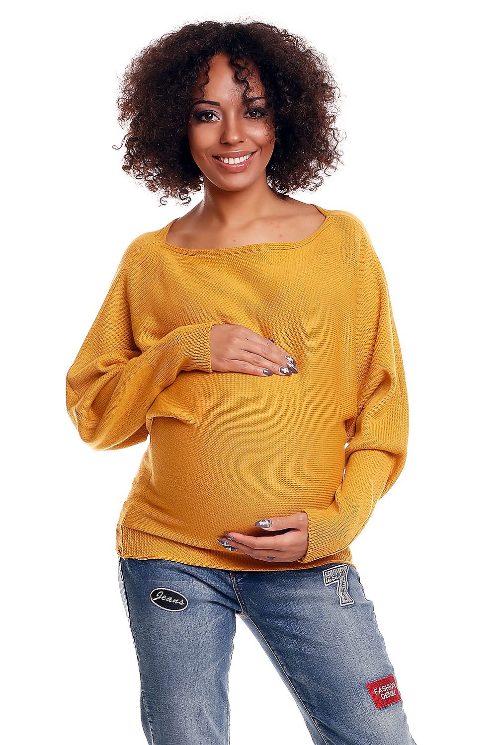 Woman wearing a mustard yellow sweater and blue jeans on a white background
