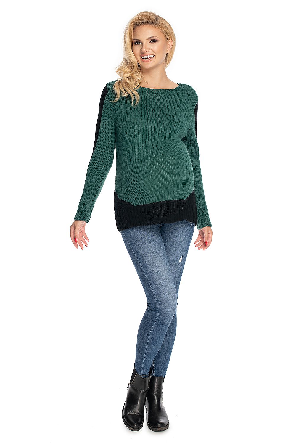 Woman wearing a green and black sweater with blue jeans on a white background