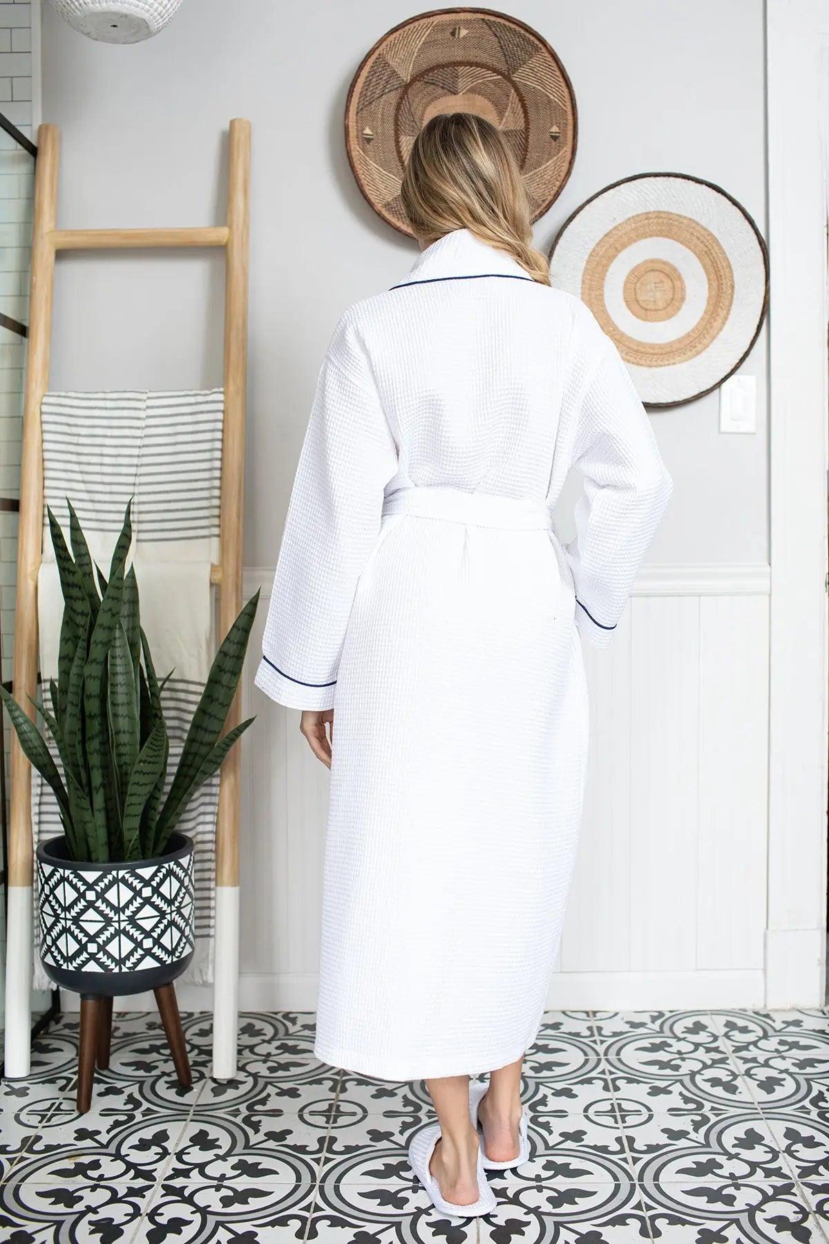 Person wearing a white robe standing in a room with decorative elements.